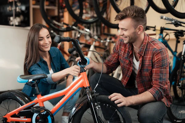Молодой парень и девушка выбирают детский велосипед . — стоковое фото