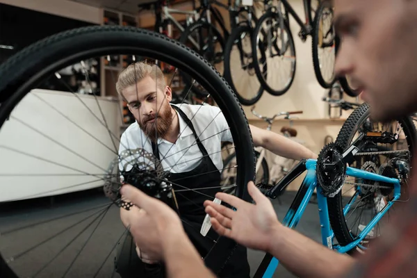 Ein junger Mann kam in die Werkstatt, um sein Fahrrad zu reparieren. — Stockfoto