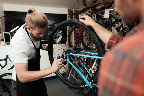 Ein junger Mann kam in die Werkstatt, um sein Fahrrad zu reparieren. — Stockfoto