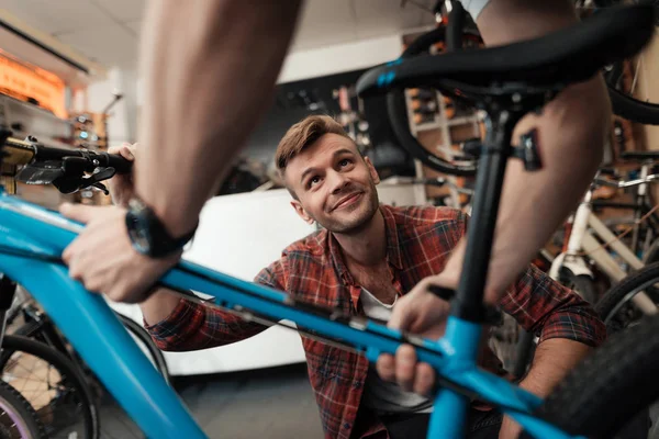 Un jeune homme est venu à l'atelier pour réparer son vélo . — Photo