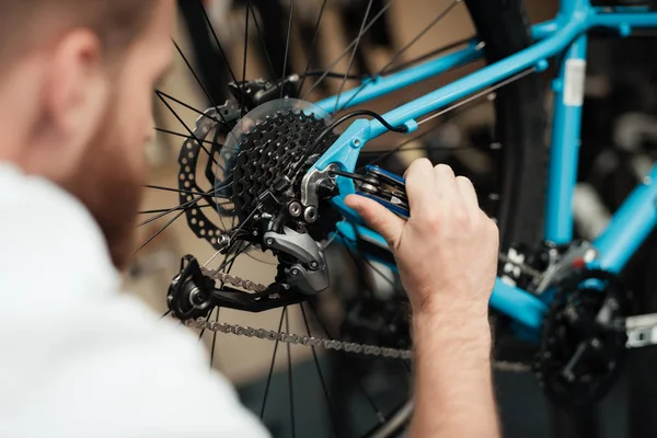 Ein junger Mann repariert ein Fahrrad. — Stockfoto