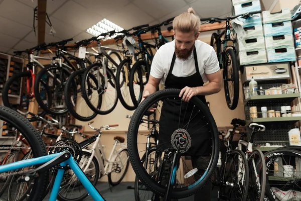 Ein junger Mann repariert ein Fahrrad. — Stockfoto