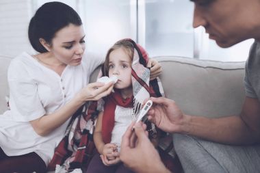 Küçük kız üşütmüş. Anne ve babasıyla ona tedavisi. Baba kızın sıcaklık ölçer