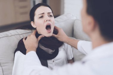 Kadın hasta düştü ve Doktor evden aradım. Bir battaniye ile kanepede oturuyor. Doktor boğazını gözlemler