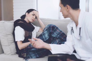Kadın hasta düştü ve Doktor evden aradım. Bir battaniye ile kanepede oturuyor. Kadın eli alnında koydu.