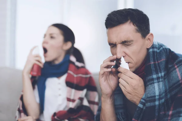 The couple is sitting on the couch wrapped in blankets. Man and woman are sick. They try to be treated — Stock Photo, Image