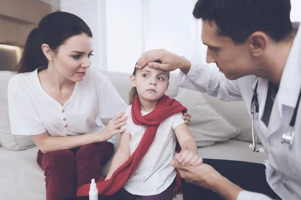 La bambina ha preso il raffreddore. Sua madre ha chiamato il dottore a casa. Il medico esamina la ragazza — Foto Stock