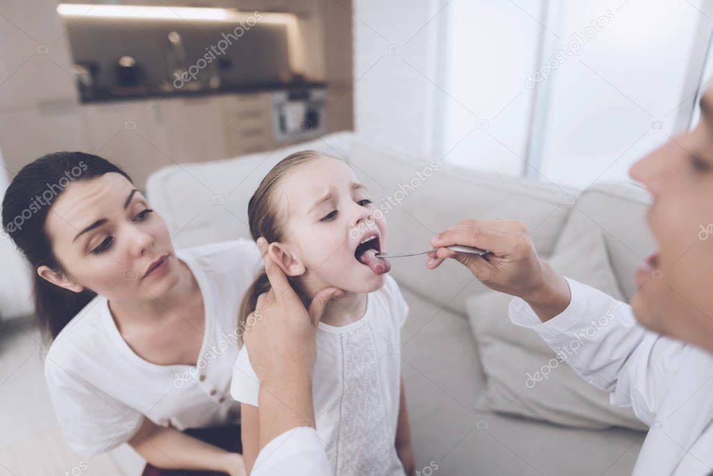 The little girl caught a cold. Her mother called the doctor at home. Doctor looks at the girl's throat