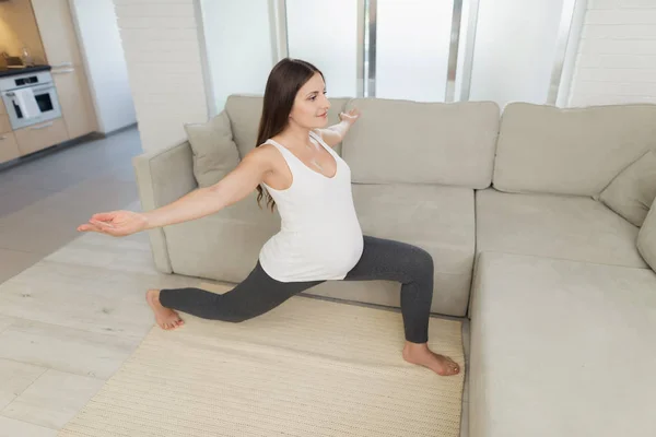 Hamile bir kadın evde hafif bir katta oturuyor. Yoga egzersizleri yapıyor — Stok fotoğraf