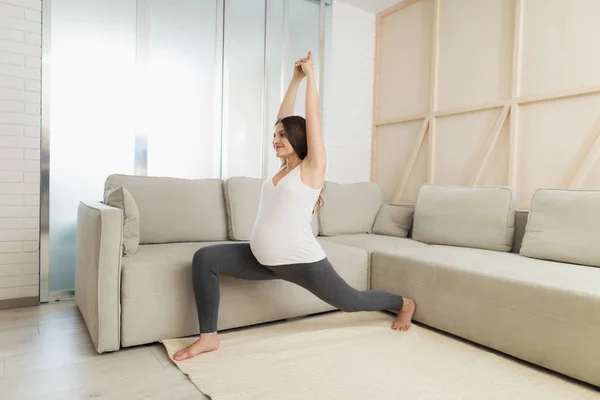 Hamile bir kadın evde hafif bir katta oturuyor. Yoga egzersizleri yapıyor — Stok fotoğraf