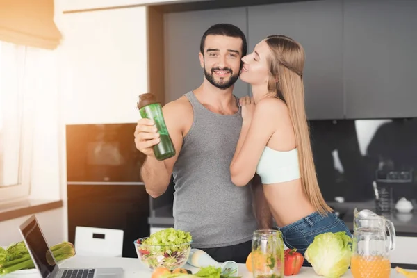 남자와 여자는 아침에 부엌에서 남자가 그의 손에 칵테일 녹색 야채와 함께 재생 됩니다.. — 스톡 사진