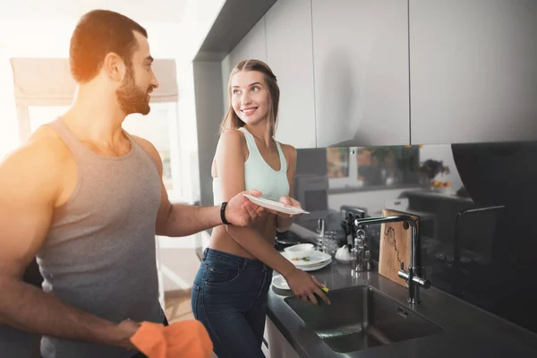 Un uomo e una donna in cucina la mattina. Lavano i piatti dopo colazione . — Foto Stock