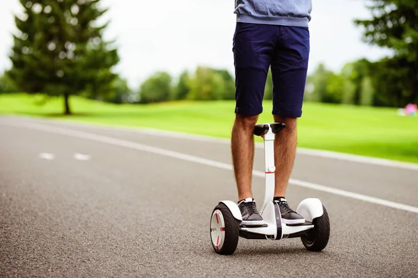 Close up. A man is driving through the park on a gyroboard. — Stock Photo, Image