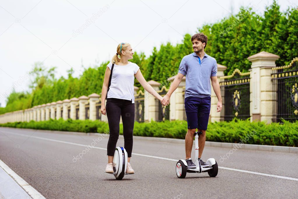 The pair is riding a gyroboard and a monocle in a country park. They are happy