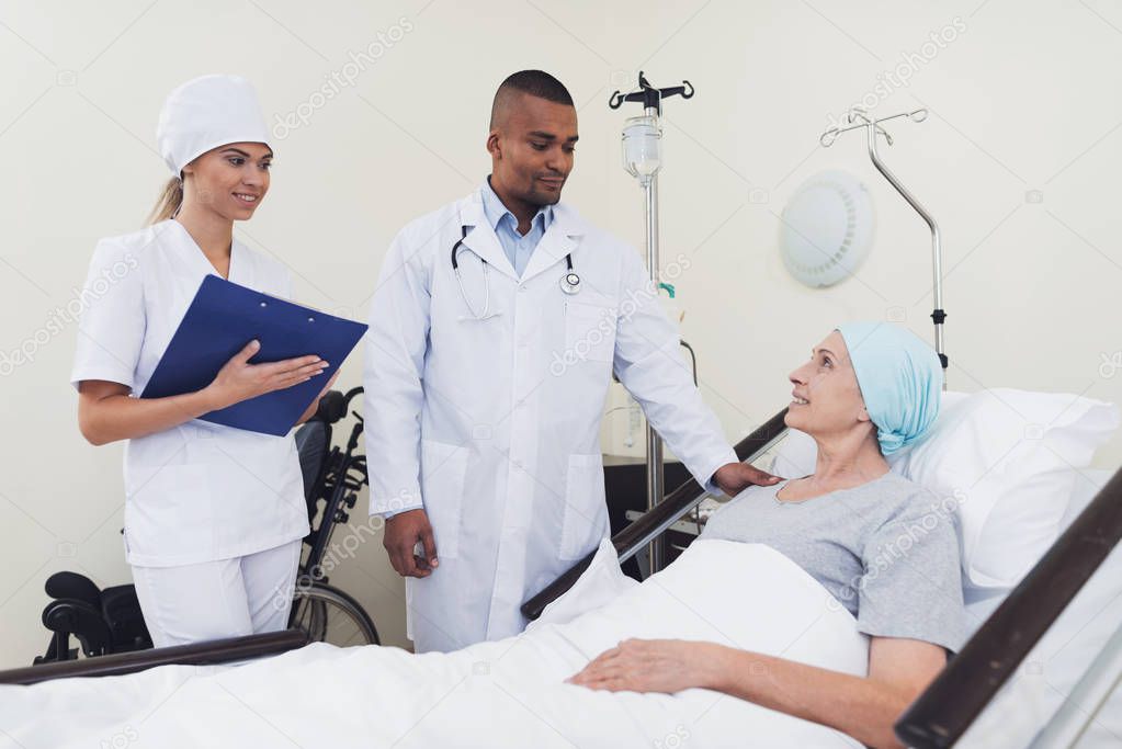 The doctor communicates with the patient. A woman is treated with cancer.