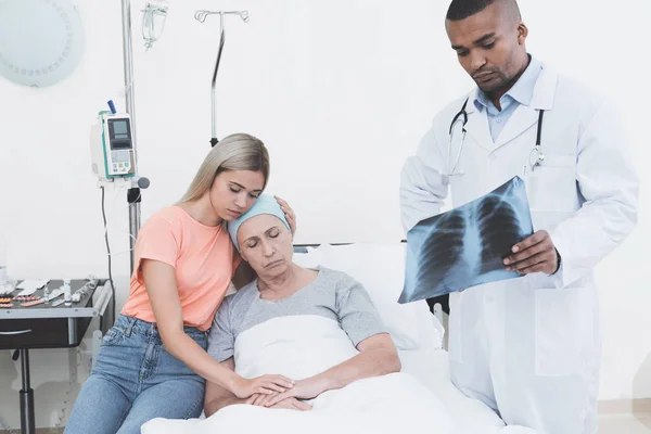 En kvinna kom till sin mor, som hade cancer. Läkaren håller hennes röntgen. — Stockfoto