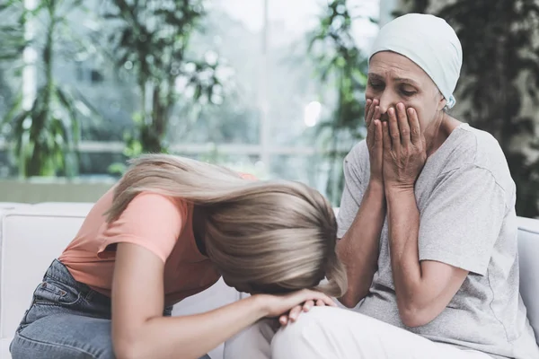 암 가진 여자는 현대 병원에서 흰색 소파에 앉아 있다. 그녀 옆에 앉아 그녀의 딸. — 스톡 사진