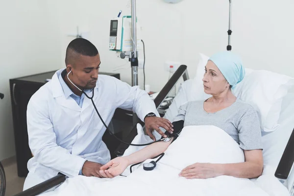 O médico mede a pressão sobre a mulher. Uma mulher passa por reabilitação após o tratamento do câncer . — Fotografia de Stock