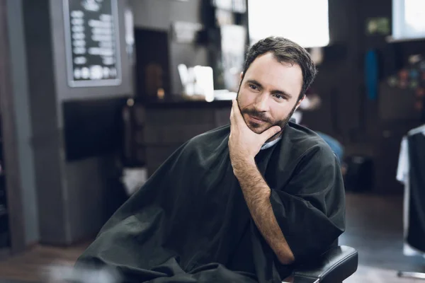 Bir adam bir erkek berber, saçını kesmek için geldiği bir berber sandalyede oturuyor. — Stok fotoğraf