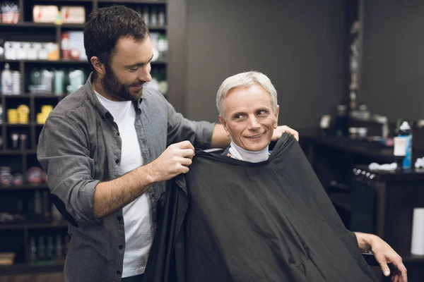 Stary człowiek siedzi w fotelu Fryzjer w człowieka fryzjera, gdzie doszedł do swojego fryzjera. — Zdjęcie stockowe