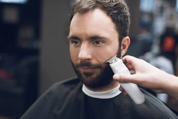 Barber je řezání vousy s mužem v kadeřnictví. — Stock fotografie