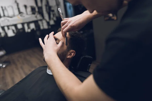 De kapper scheert zijn hoofd, snor en baard aan de man in de barbershop. — Stockfoto