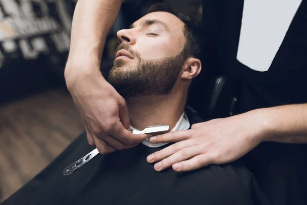 El barbero se afeita la cabeza, el bigote y la barba al hombre de la barbería . — Foto de Stock