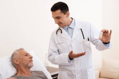 Yaşlı adam yalanlar üzerine bir karyola tıbbi koğuşta ve onun yanında bir doktor duruyor. Bir şey için yaşlı adamı tarif etmeye yeterli..