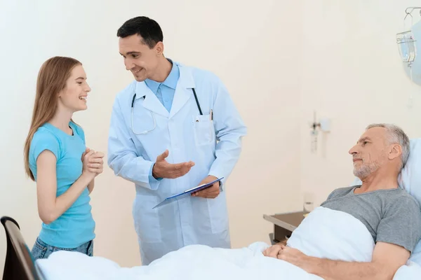 Ein älterer Mann liegt in einem Krankenhauszimmer auf einem Bett. Er befindet sich in der Rehabilitation. Neben ihm ein Arzt. — Stockfoto