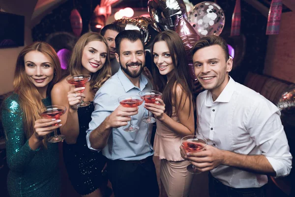 Los jóvenes se divierten en un club nocturno. Beben cócteles y se divierten. Se están divirtiendo. . —  Fotos de Stock