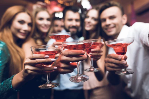 Молодые люди веселятся в ночном клубе. Они пьют коктейли и веселятся. . — стоковое фото