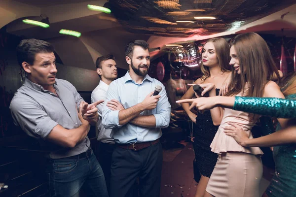 Ungdomar har kul i en nattklubb. Tre män och tre kvinnor iscensatt en musikalisk strid. — Stockfoto