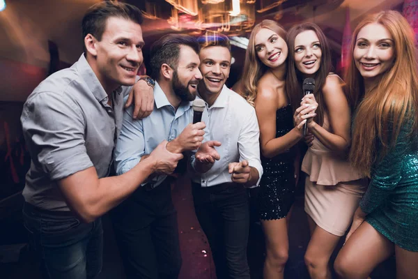 Genç insanların eğlenceli bir gece kulübünde yok. Üç erkek ve üç kadın bir müzikal savaş düzenledi. — Stok fotoğraf