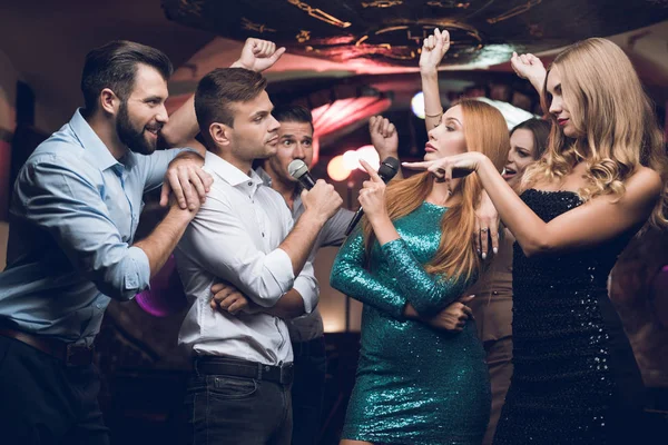 Jugendliche haben Spaß in einem Nachtclub. Drei Männer und drei Frauen inszenierten eine musikalische Schlacht. — Stockfoto