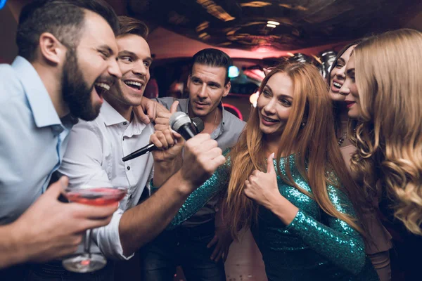 Jugendliche haben Spaß in einem Nachtclub. Drei Männer und drei Frauen inszenierten eine musikalische Schlacht. — Stockfoto