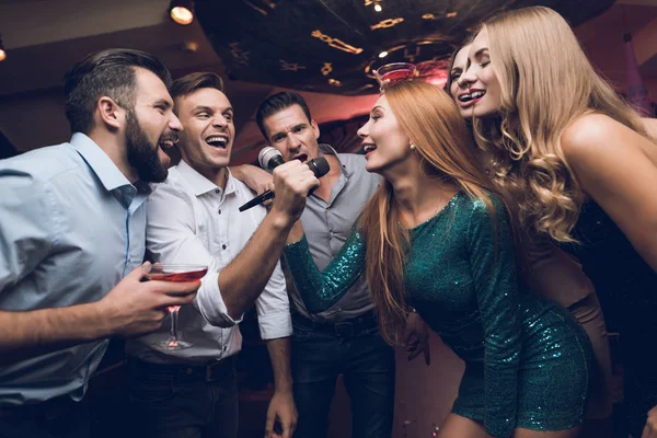 Νέοι άνθρωποι έχουν διασκέδαση σε νυχτερινό κέντρο διασκέδασης. Τρεις άντρες και τρεις γυναίκες ανέβασε μια μουσική μάχη. — Φωτογραφία Αρχείου