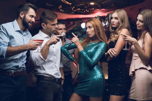 Jugendliche haben Spaß in einem Nachtclub. Drei Männer und drei Frauen inszenierten eine musikalische Schlacht. — Stockfoto