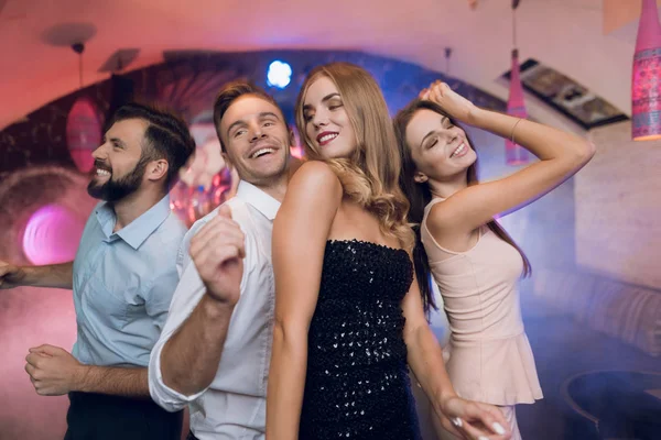 Im Vordergrund tanzen ein Mann und eine Frau. Hinter ihnen tanzen und singen sie ihre Freunde. — Stockfoto