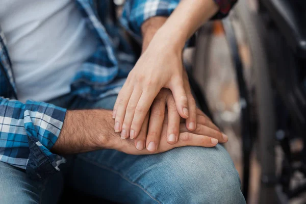 Närbild. Ett par av invalider på rullstolar träffade i parken. En man och en kvinna sitter hålla händerna. — Stockfoto