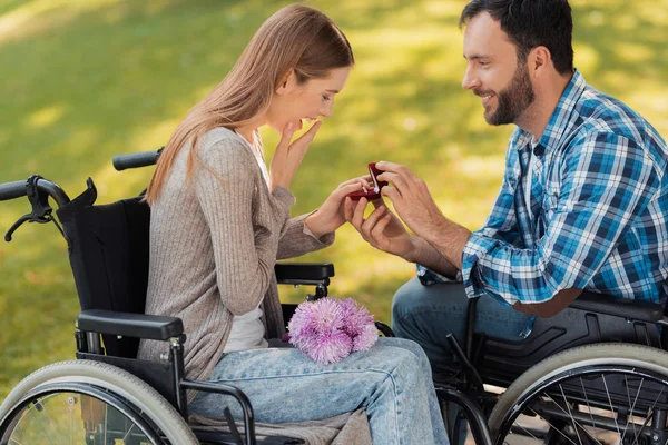 Un homme et une femme en fauteuil roulant se sont rencontrés dans le parc. Un homme fait d'une femme une prépossession . — Photo