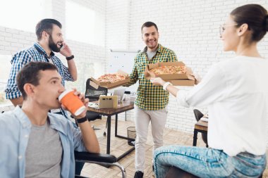 Ofis çalışanları ve adam tekerlekli sandalyede pizza yiyorlar. Onlar bir aydınlık ve modern ofis iş.