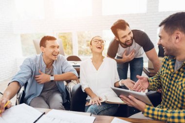 Ofis çalışanları ve tekerlekli sandalye bir kişi çalışma sorunlarını tartışmak. Onlar parlak bir ofiste çalışmak.