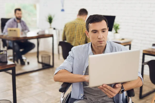 La persona disabile sulla sedia a rotelle lavora in ufficio al computer . — Foto Stock