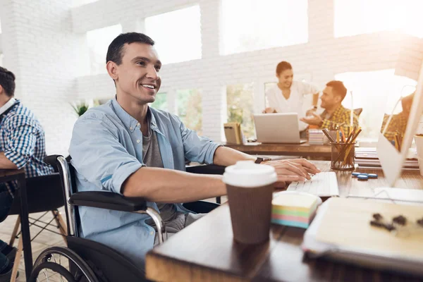 Pessoa com deficiência na cadeira de rodas trabalha no escritório no computador . — Fotografia de Stock