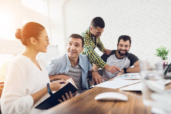 Ofis çalışanları ve tekerlekli sandalye bir kişi çalışma sorunlarını tartışmak. Onlar parlak bir ofiste çalışmak.