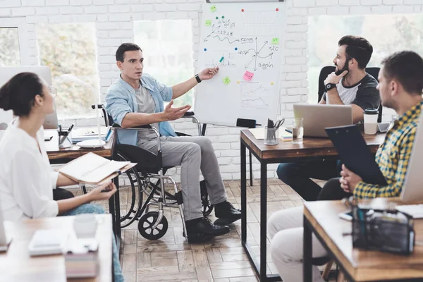 Υπάλληλοι γραφείου και άνθρωπος σε μια αναπηρική καρέκλα συζητώντας επαγγελματίες στιγμές σε ένα σύγχρονο γραφείο. — Φωτογραφία Αρχείου