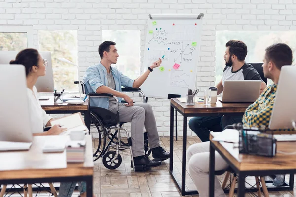 Administrativní pracovníci a muž na invalidním vozíku, diskuse o obchodní okamžiky v moderní kanceláři. — Stock fotografie