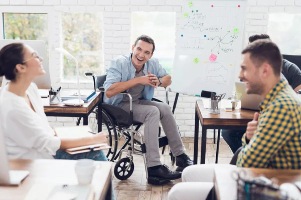 Lavoratori d'ufficio e uomo in sedia a rotelle discutono di momenti di lavoro in un ufficio moderno . — Foto Stock