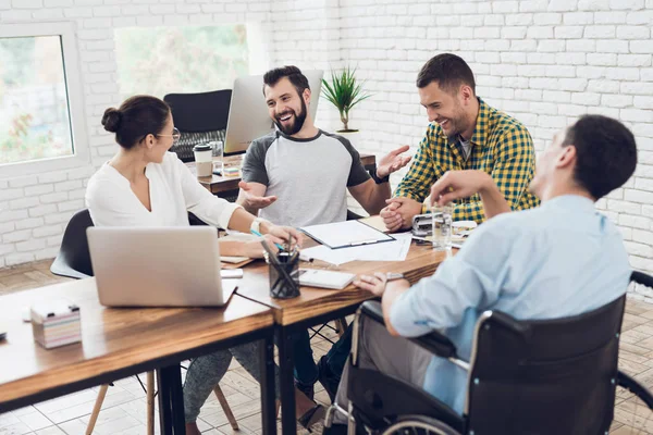 Un grupo de jóvenes discutiendo negocios mientras trabajan en la oficina . — Foto de Stock