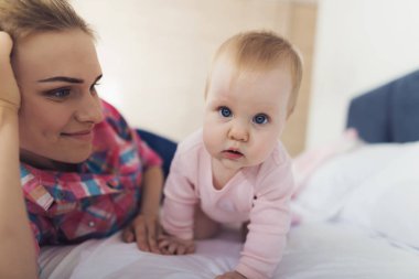 Bir kadın bebek yanındaki yatakta yatıyor. O bebeğin yatağına koyacağız.